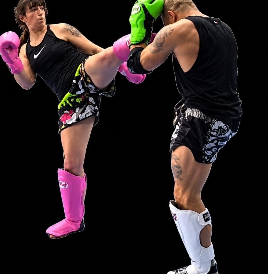 Puntada alta en una sessió de Muay Thai, amb guants i canyelleres